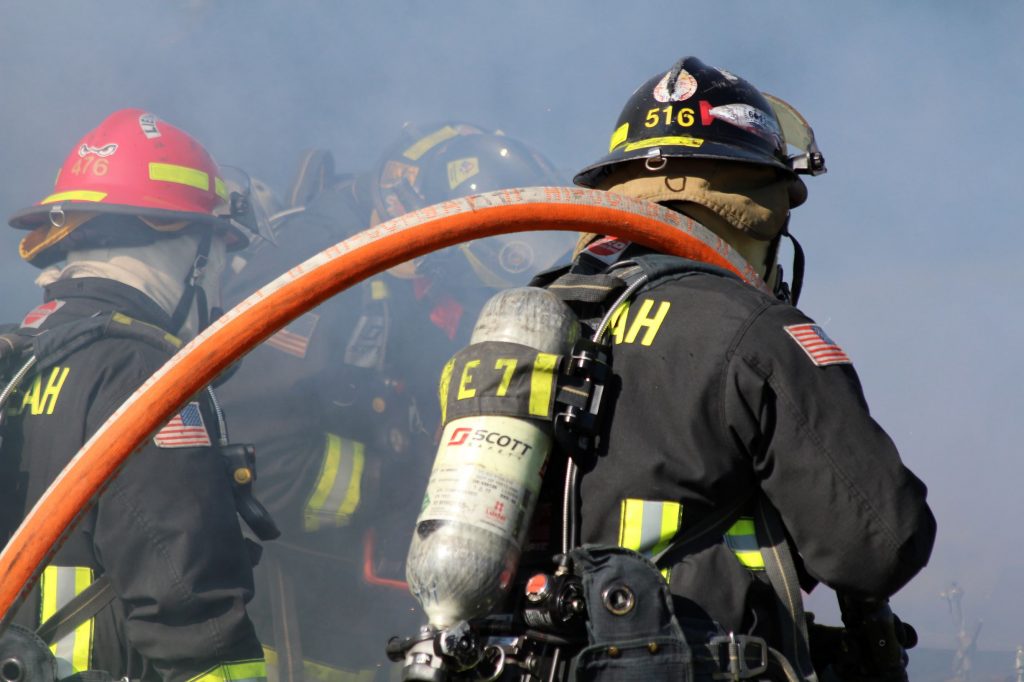Firefighter with hose over shoulder