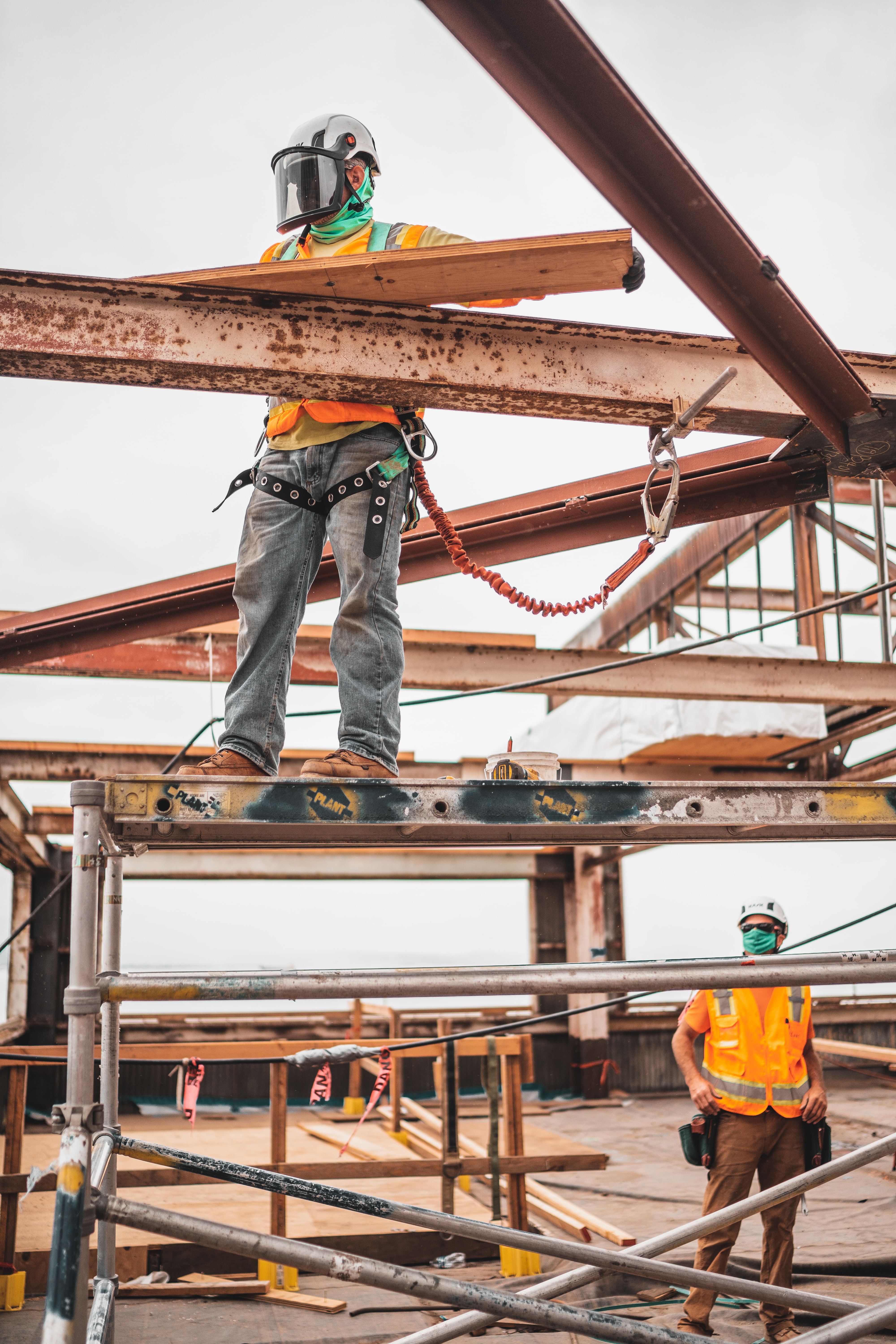 construction workers holding steel beam